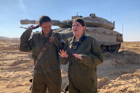 Zwei Soldatinnen der Caracal-Brigade der israelischen Streitkräfte, vor einem Panzer stehend