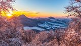 Die Sonne geht hinter den drei Kaiserbergen nahe Hornberg in Baden-Württemberg unter. Willkommen im Winterwunderland!