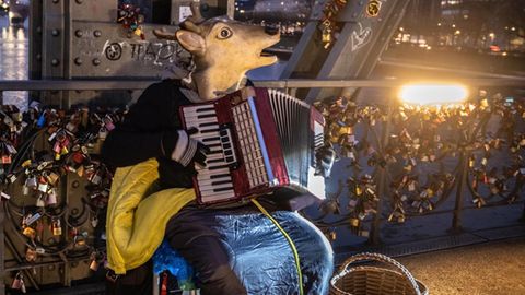 Ein Straßenmusiker spielt auf einer Brücke in Frankfurt am Mai Akkordeon.