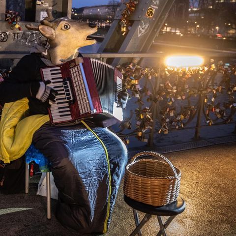 Ein Straßenmusiker spielt auf einer Brücke in Frankfurt am Mai Akkordeon.