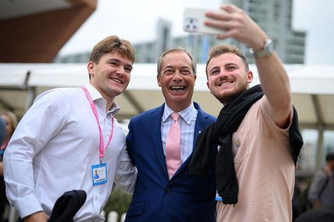Nigel Farage eingerahmt von zwei jungen Männern, die ein Selfie mit ihm machen