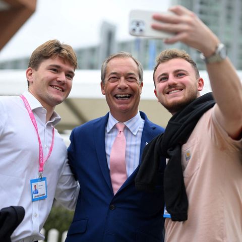 Nigel Farage eingerahmt von zwei jungen Männern, die ein Selfie mit ihm machen