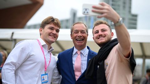 Nigel Farage eingerahmt von zwei jungen Männern, die ein Selfie mit ihm machen