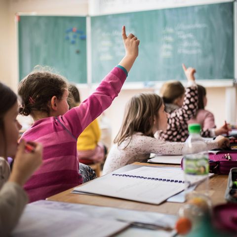PISA-Studie: Schülerinnen melden sich im Klassenraum
