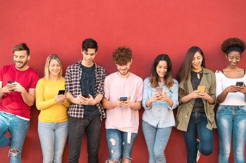 Linux-Smartphone: Junge Menschen stehen in einer Reihe und schauen auf ihre Handys