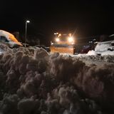 Räumfahrzeuge befreien am frühen Morgen einen Firmenparkplatz in Kempten vom Schnee