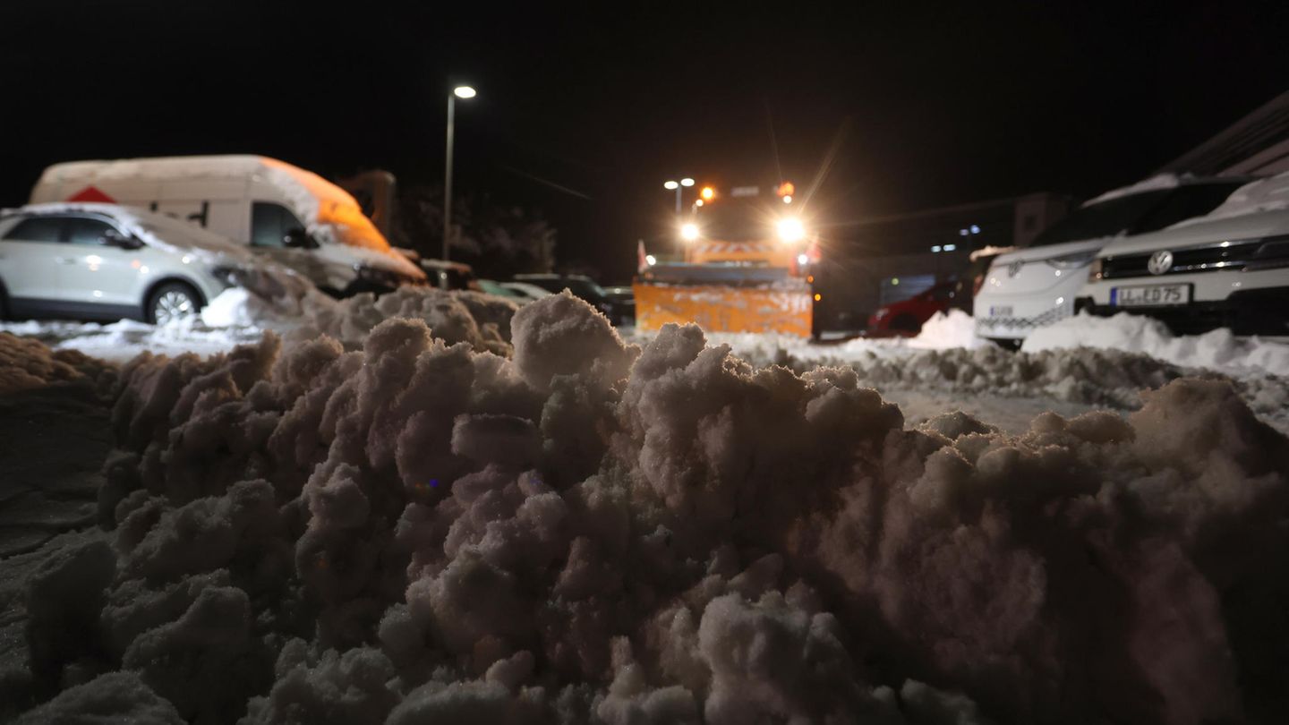 Räumfahrzeuge befreien am frühen Morgen einen Firmenparkplatz in Kempten vom Schnee