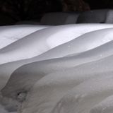 Autos stehen mit Schnee bedeckt auf dem Parkplatz eines Autohändlers im bayerischen Kempten
