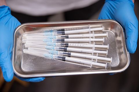 Aufgezogene Spritzen mit Impfstoff gegen Covid-19 liegen in einer Schale