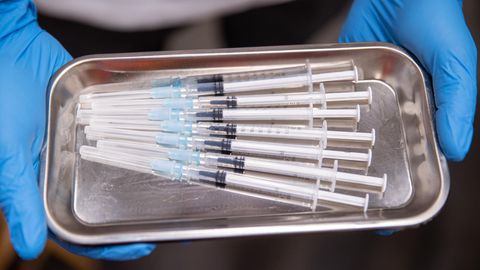 Aufgezogene Spritzen mit Impfstoff gegen Covid-19 liegen in einer Schale