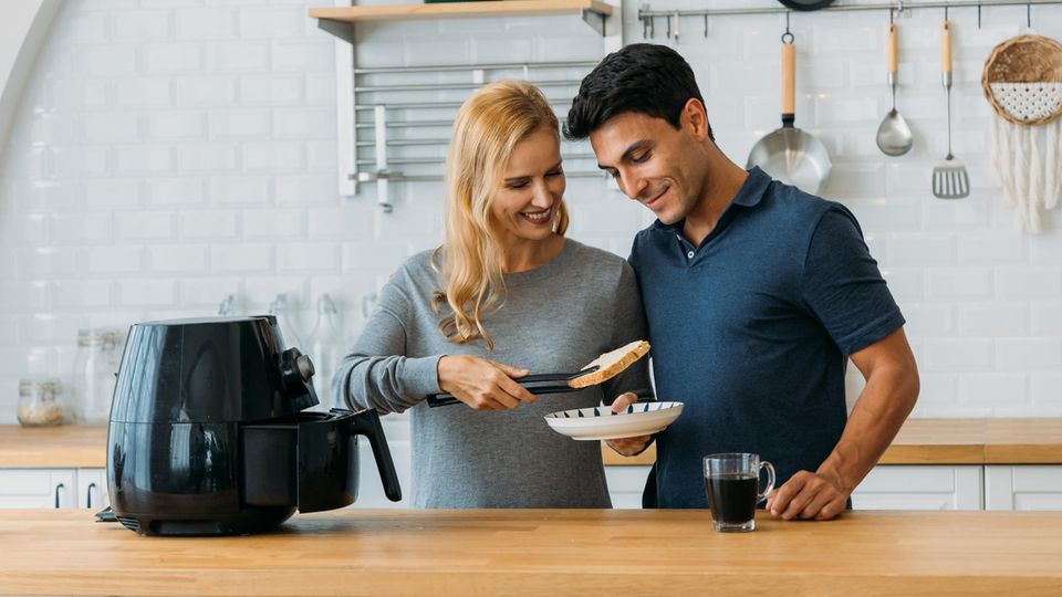 Mann und Frau kochen mit Multikocher