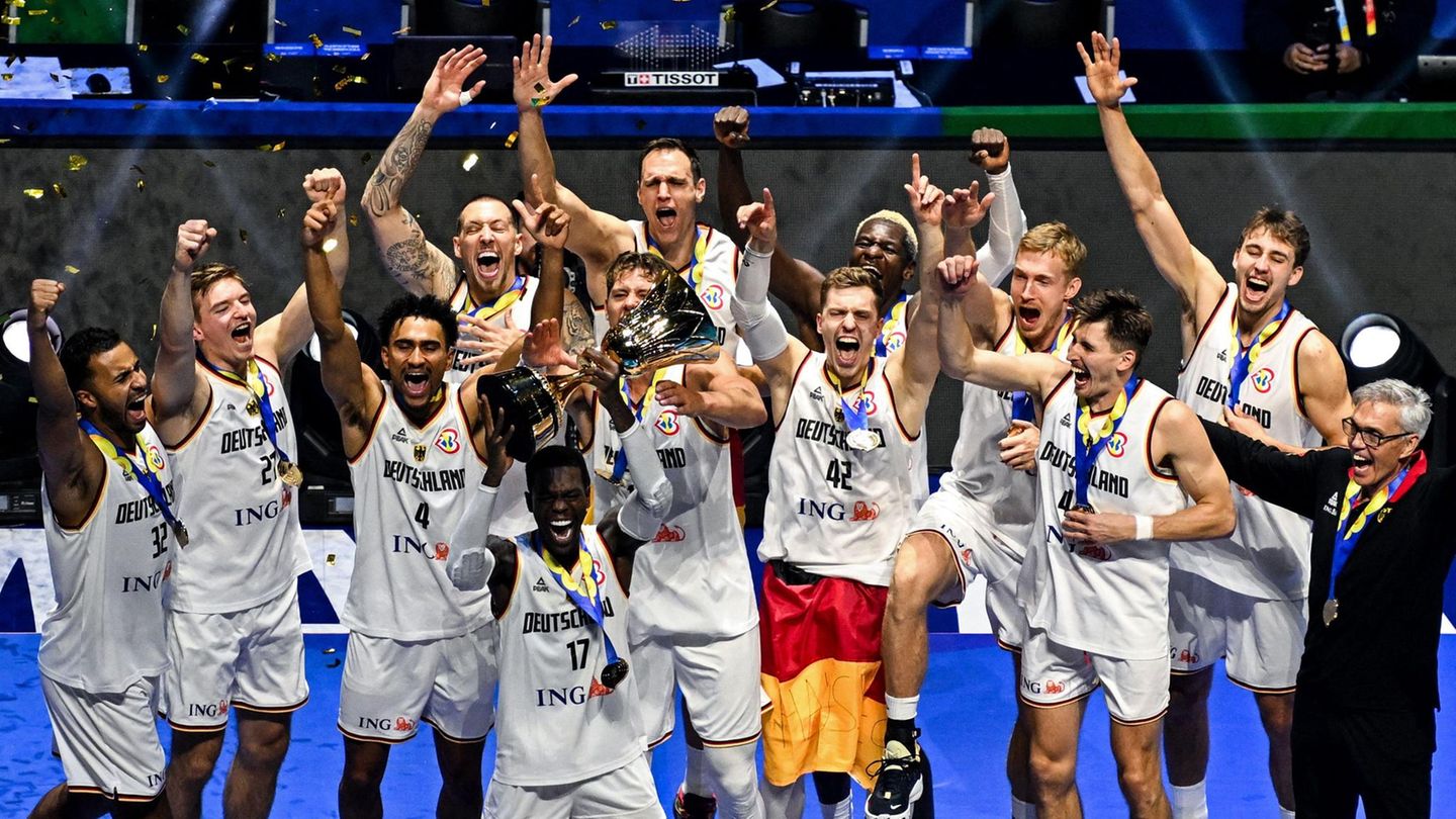 Die Basketball Mannschaft feiert mit dem Pokal