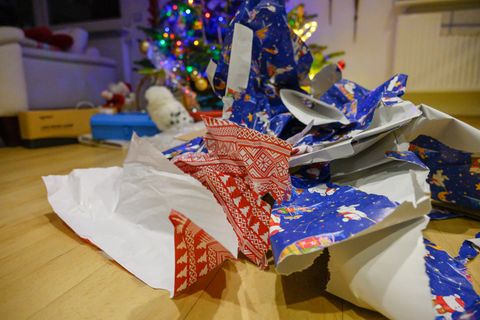 Viel Müll: Geschenkpapier stapelt sich nach der Bescherung unter einem Tannenbaum