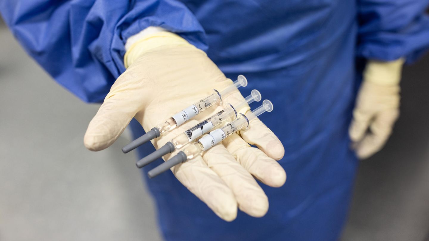 Drei Spritzen mit Corona-Impfstoff liegen in der Hand eines Arztes oder einer Ärztin