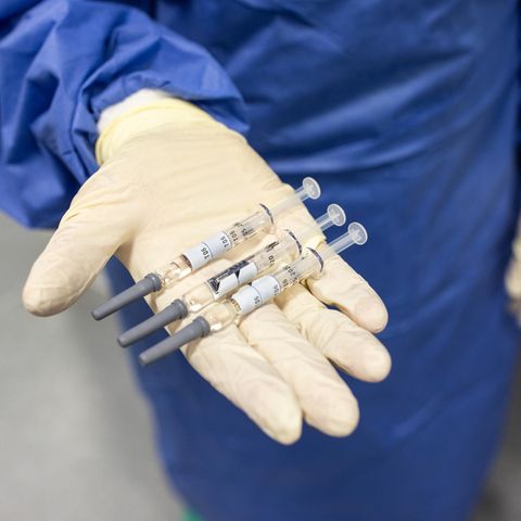 Drei Spritzen mit Corona-Impfstoff liegen in der Hand eines Arztes oder einer Ärztin