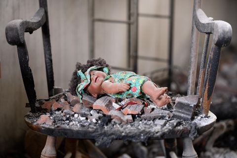 Eine Puppe liegt auf einem Schaukelstuhl liegt in einem zerstörten Haus im Kibbuz Beeri