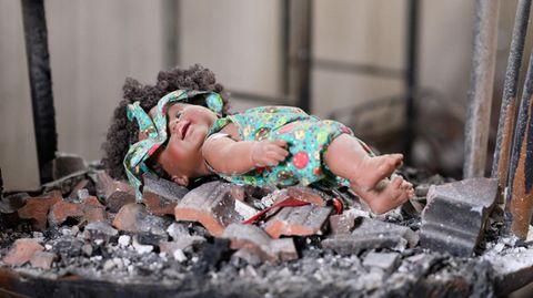Eine Puppe liegt auf einem Schaukelstuhl liegt in einem zerstörten Haus im Kibbuz Beeri