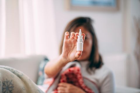 Nasenspray Sucht: Eine Frau hält eine Sprühfläschchen in der Hand