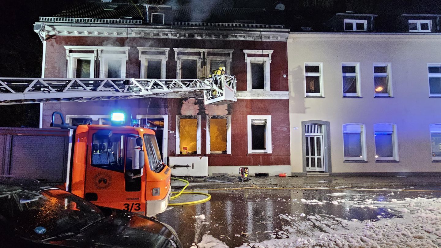 Feuerwehrleute löschen einen Brand in einem Mehrfamilienhaus in Essen