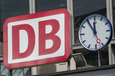Eine Uhr hängt neben dem Logo der Deutschen Bahn am Eingang zum Münchner Hauptbahnhof