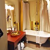 … zum Bad mit Badewanne auf Füßen. Der Fön hängt in einem Beutel an der Wand, „Come as you are, but be dry“.