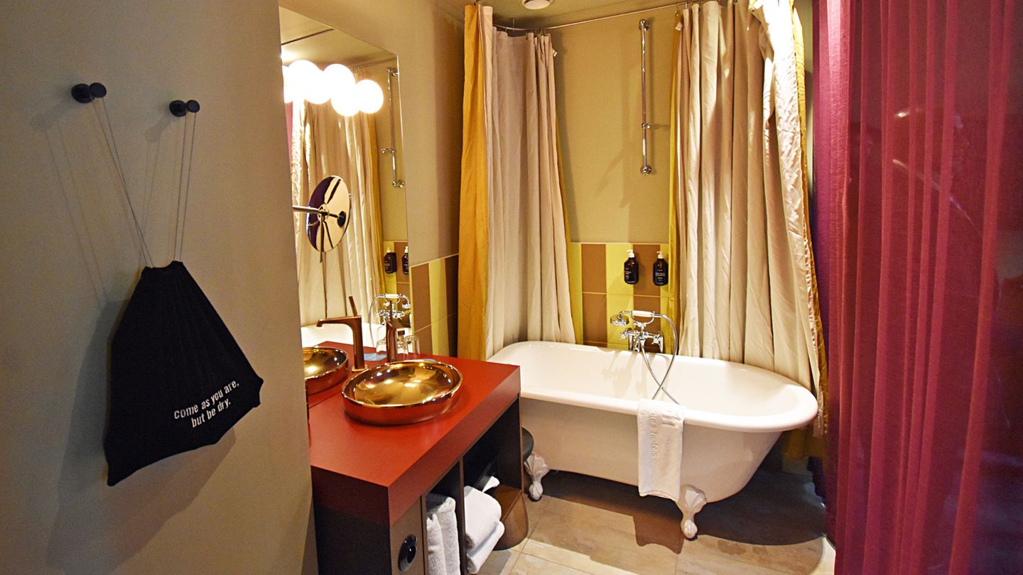 … zum Bad mit Badewanne auf Füßen. Der Fön hängt in einem Beutel an der Wand, „Come as you are, but be dry“.