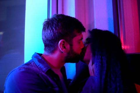 Ein junges Paar knutscht in einem Club