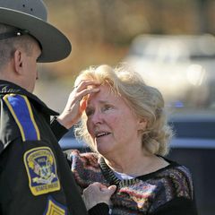 Eine aufgebrachte Frau spricht nach dem Amoklauf an der Sandy Hook Grundschule mit einem Polizeibeamten