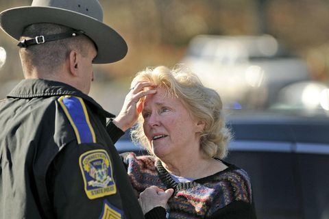 Eine aufgebrachte Frau spricht nach dem Amoklauf an der Sandy Hook Grundschule mit einem Polizeibeamten
