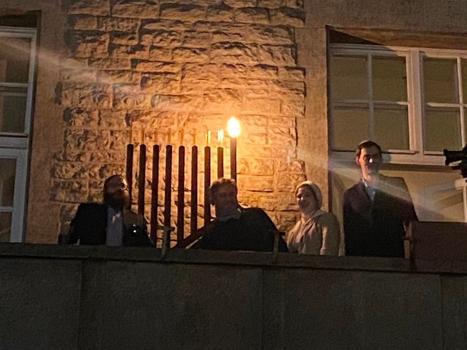 Chanukka Feier Menschen stehen auf einem Balkon vor einem Chanukka Leuchter am Rathaus in Berlin Neukölln