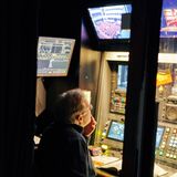 Ein Mann sitzt vor vielen Bildschirmen und Knöpfen