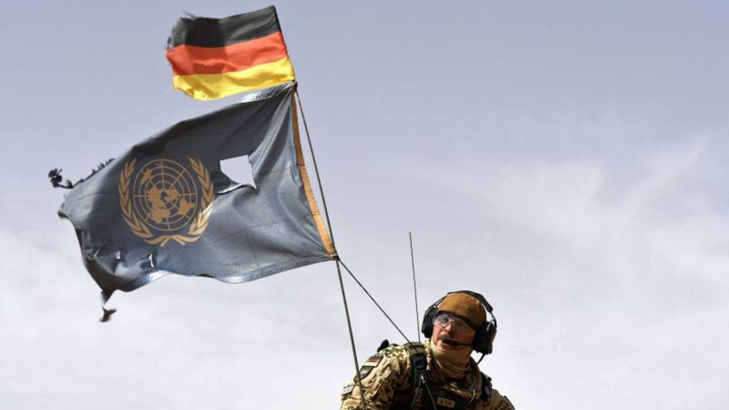 Ein Bundeswehrsoldat mit deutscher und UN-Flagge beim Einsatz in Mali