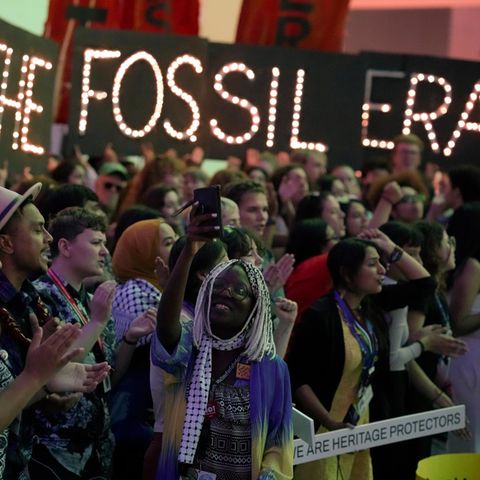 "Beendet die fossile Ära" steht auf Plakaten während einer Demonstration auf dem UN-Klimagipfel in Dubai