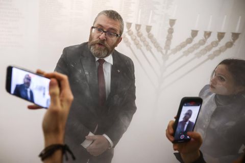 Grzegorz Braun, ein Mitglied der rechtsextremen Konföderationspartei, nachdem er im polnischen Parlament Kerzen eines Chanukka-Leuchters gelöscht hat