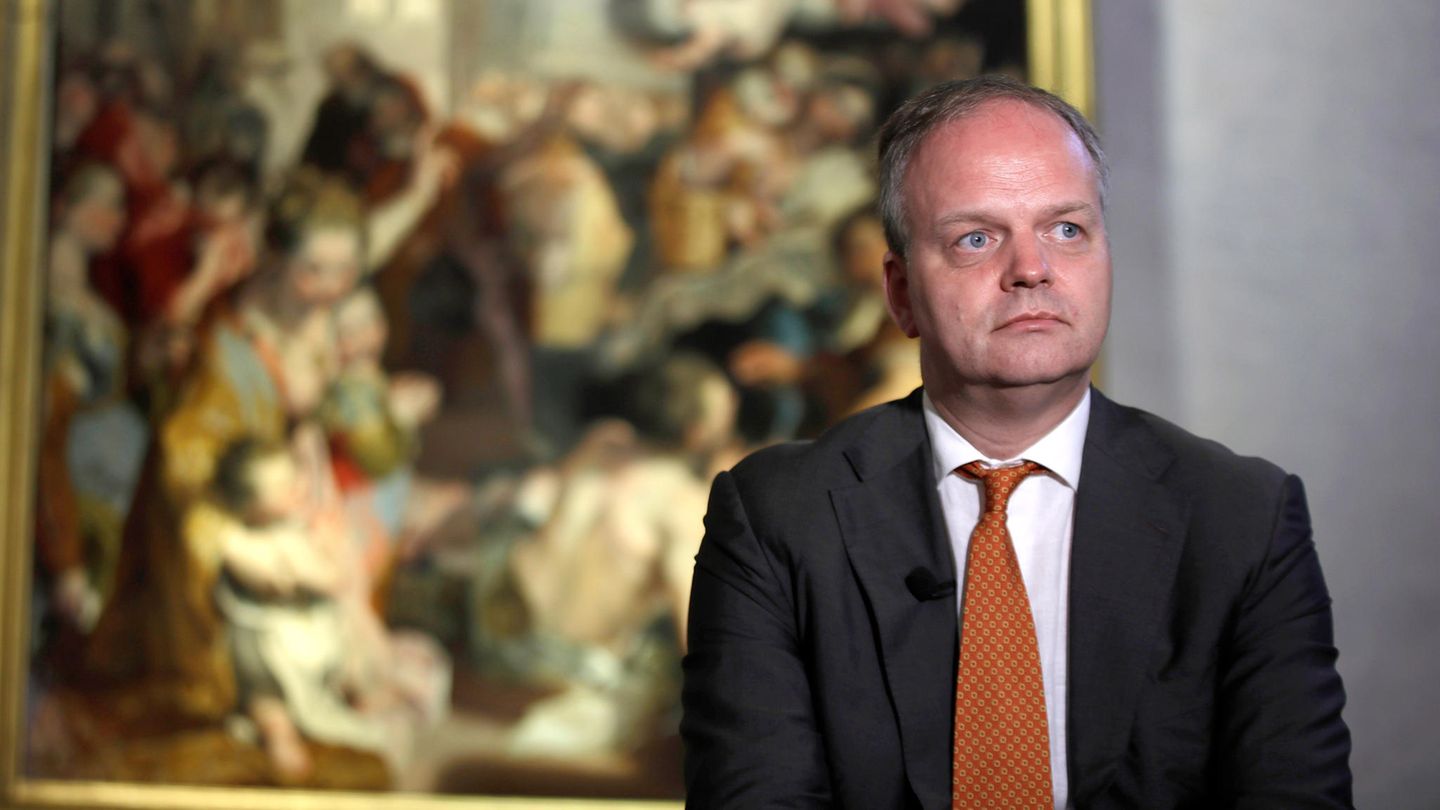 Eike Schmidt steht ernst vor einem Gemälde, das verschwommen im Hintergrund zu sehen ist Eike Schmidt steht ernst vor einem Gemälde, das verschwommen im Hintergrund zu sehen ist