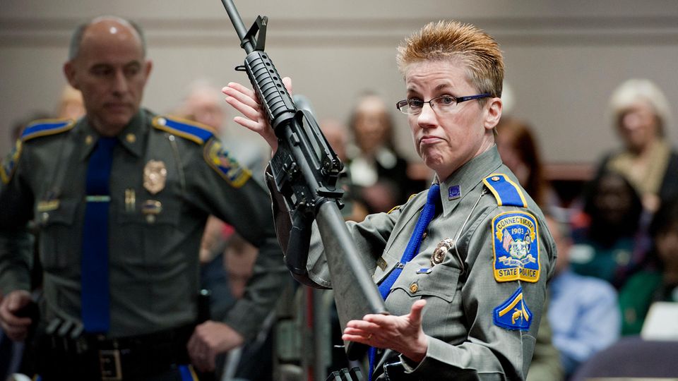 Eine Polizistin präsentiert eine Bushmaster AR-15. Mit einer solchen Waffe tötete Adam Lanza seine Opfer