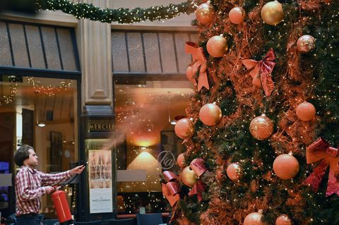 Ein Mitglied der Protestgruppe "Letzte Generation" besprüht einen Tannenbaum in der Leipziger Mädler-Passage
