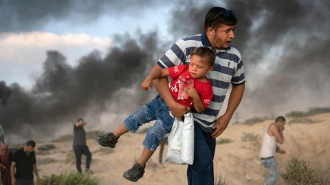 Ein Mann trägt einen kleinen Jungen im palästinensischen Konfliktgebiet