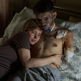 Eine Frau und ihr durch den Krieg schwerverletzter Ehemann liegen im Krankenhaus Bett