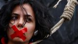 Eine Frau mit zugeklebtem Mund und schlinge um den Hals, auf einem "woman, life, freedom" protestmarsch