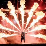 Sänger Till Lindemann live auf der Bühne, umgeben von Flammen, zu sehen.