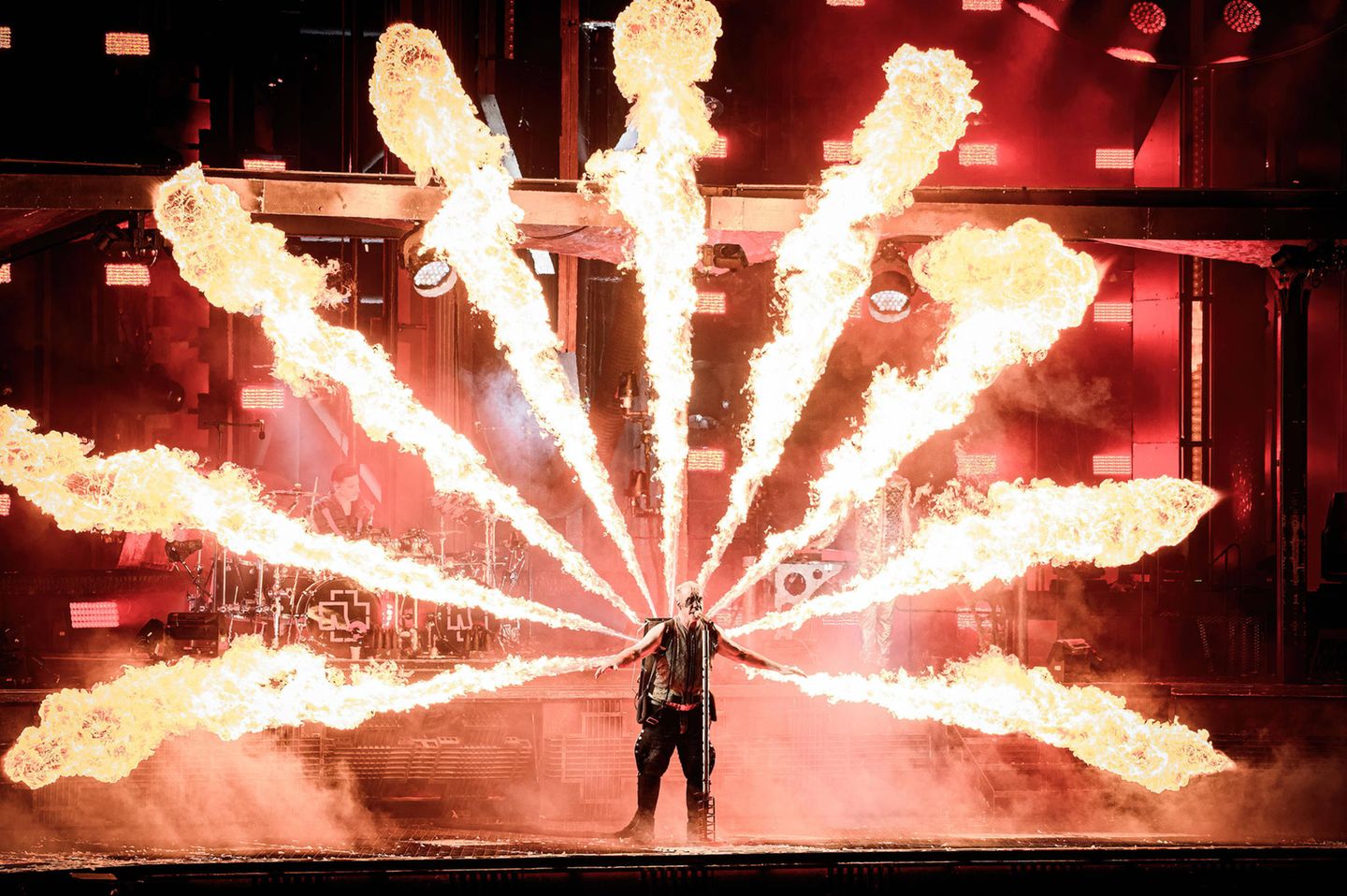 Sänger Till Lindemann live auf der Bühne, umgeben von Flammen, zu sehen.