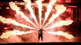 Sänger Till Lindemann live auf der Bühne, umgeben von Flammen, zu sehen.
