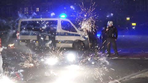 Polizisten stehen in explodierendem Feuerwerk. Vielerorts gilt Silvester ein Böllerverbot
