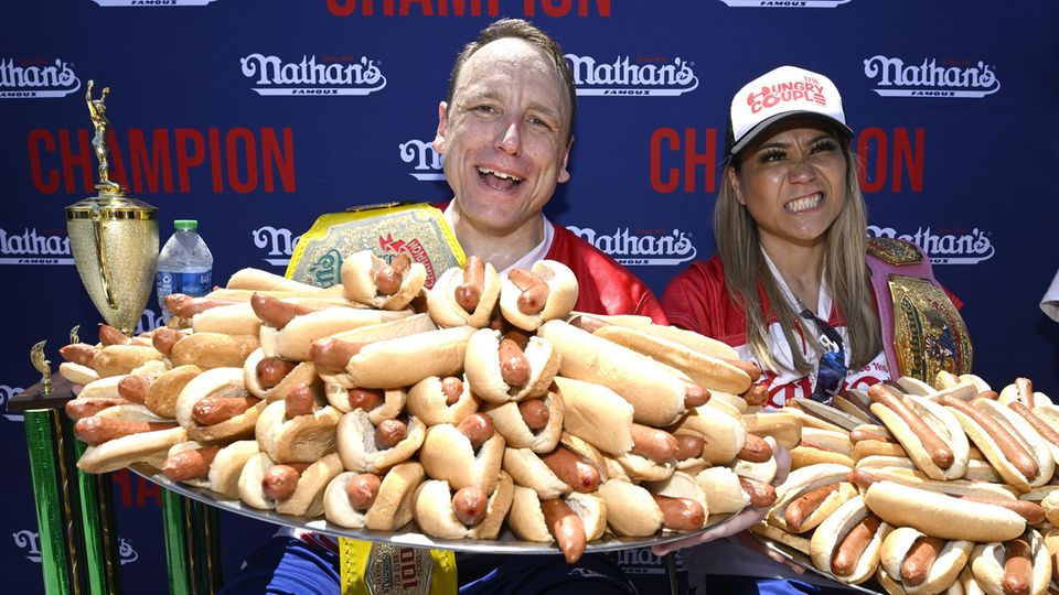 Joey Chestnut mit einem riesigen Teller voller Hotdogs Joey Chestnut mit einem riesigen Teller voller Hotdogs