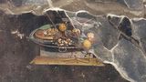 2000 Jahre altes Wandgemälde in Pompeji, das einen entfernten Vorgänger der Pizza zeigt