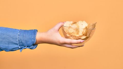 Gewohnheiten ändern: Eine Frau hält eine Schüssel mit Chips in der Hand