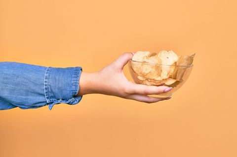 Gewohnheiten ändern: Eine Frau hält eine Schüssel mit Chips in der Hand