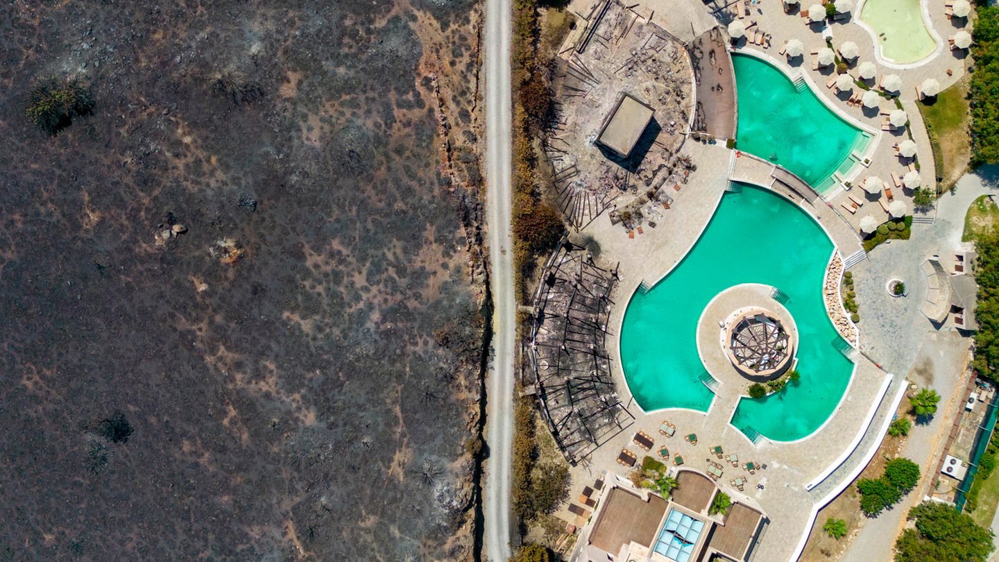 August: Rhodos geht in Flammen auf Kiotari, Griechenland: Wie eine schützende Schneise hat eine Straße ein Hotel vor den verheerenden Flammen gerettet. Der Waldbrand auf der greichischen Ferieninsel Rhodos geht als der größten in der Geschichte Griechenlands ein. 20.000 Menschen mussten in Sicherheit gebracht werden.