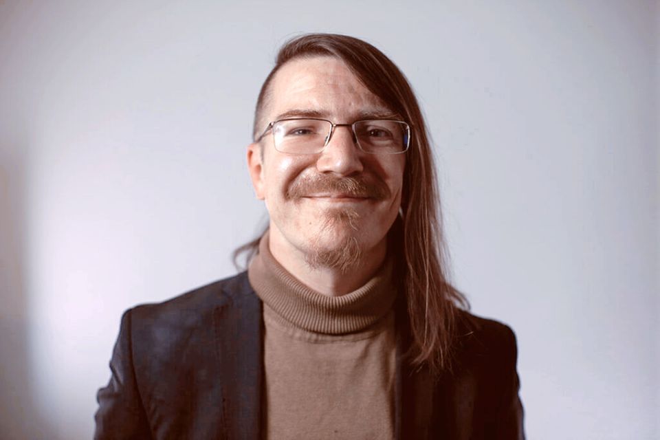 Porträt Christian Fein mit langen Haaren, einseitig rasiert